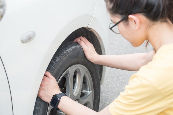 Woman with glasses changing tire